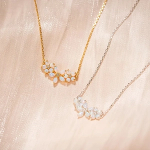Elegante Gold- und Silber-Opal-Halsketten mit funkelnden Steinen auf Seidenhintergrund