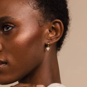 Detail of 18K gold plated opal drop earrings on model showing minimalist grape design
