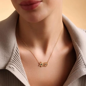 Elegant gold flower bouquet necklace with green and blue gemstones on a female model