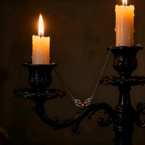 Collana gotica con mani di scheletro argentate che stringono un ciondolo a cuore rosso