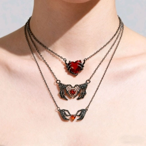 Dettaglio della collana gotica a tre strati con cuori rossi e artigli di scheletro neri