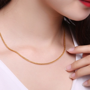 Close-up of 1.5mm golden Chopin wheat chain necklace worn on neck for fashion