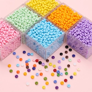 Primer plano de cuentas de vidrio de 5 mm de colores en una caja de almacenamiento transparente