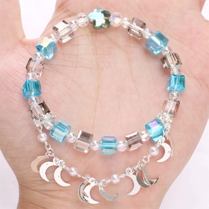 Detailansicht eines Perlenarmbandes mit blauen Kristallen und silbernen Mondanhängern
