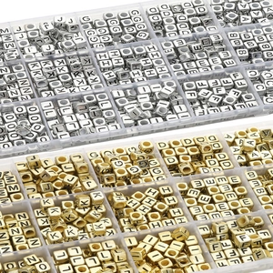 Detail view of alphabet beads set in silver and gold stored in a plastic organizer box
