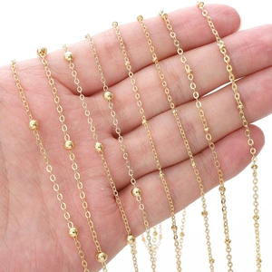 Golden brass satellite chain with small beads for DIY jewelry making displayed on hand