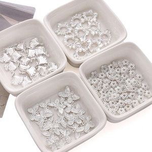 Macro view of silver hollow butterfly and lotus metal charms for DIY jewelry making