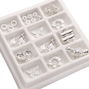 Macro view of assorted silver alloy DIY jewelry charms including butterflies and leaves