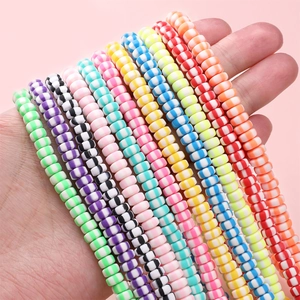 Bunte 6x3mm gestreifte flache Rundperlen aus Ton für DIY-Schmuck in der Hand
