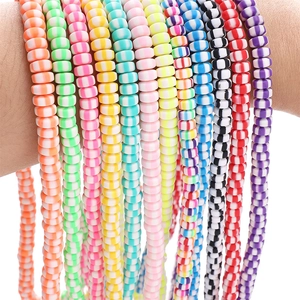 Macro shot of colorful striped polymer clay disc beads on wrist for DIY jewelry making