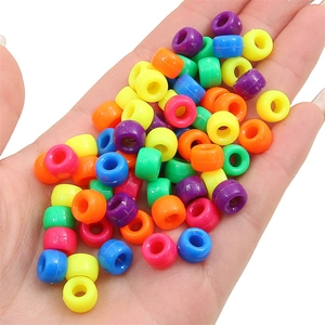 Colorful acrylic pony beads held in palm to show size for DIY bracelet making projects