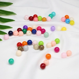 Kleurrijke ronde acryl kralen voor DIY sieraden maken op witte stoffen achtergrond