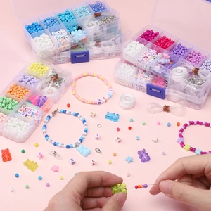 DIY Schmuck-Set Makro zeigt Hände beim Basteln von Perlenarmbändern mit Anhängern