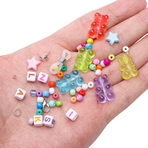 DIY Schmuckset mit bunten Harzbären und Buchstabenperlen in der Handfläche präsentiert