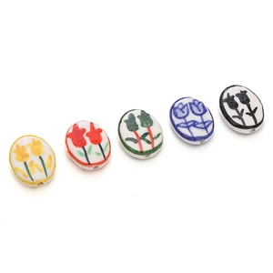 Macro detail of five hand-painted ceramic tulip beads in various colors for DIY jewelry