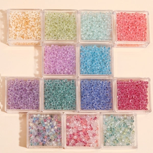 Detailed view of colorful glass seed beads in clear plastic storage boxes for DIY jewelry