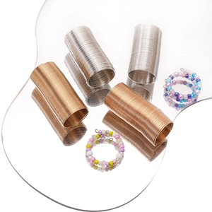 Detail von mehrschichtigen Stahldraht-Memory-Spulen und bunten Perlenarmbändern auf Tablett