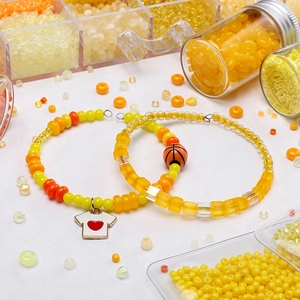 Detailed macro view of vibrant orange glass beads jewelry with DIY heart and basketball charms