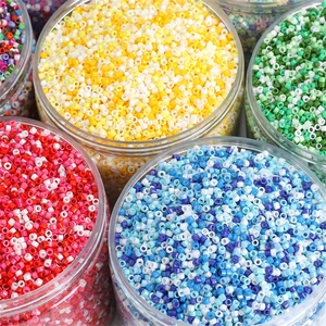 Gekleurde glaskraaltjes in transparante potjes voor het zelf maken van sieraden