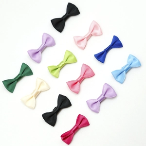 Gros plan de petits nœuds en ruban satiné coloré pour accessoires de cheveux DIY
