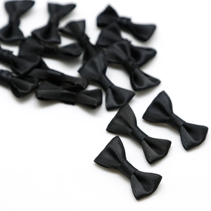 Gros plan de plusieurs nœuds en satin noir pour accessoires de cheveux DIY et artisanat