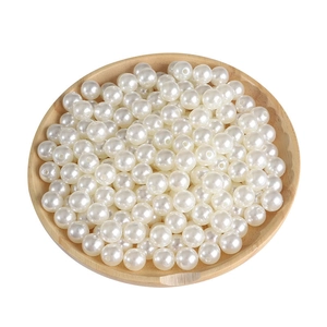 Perles en acrylique blanc poli avec trous dans un plateau en bois pour bijoux DIY
