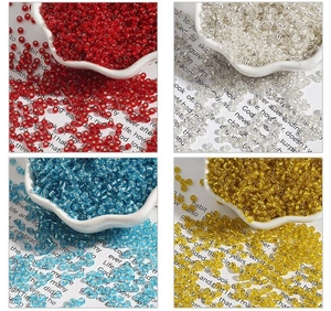 Makro-Detail von 2-4mm Glasperlen in Rot Blau und Gold für DIY-Schmuckherstellung