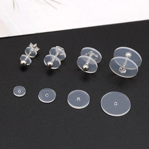 Close-up of clear silicone piercing discs in various sizes on silver stud earrings