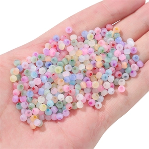 Colorful frosted cat-eye glass beads for DIY jewelry making held in palm to show scale