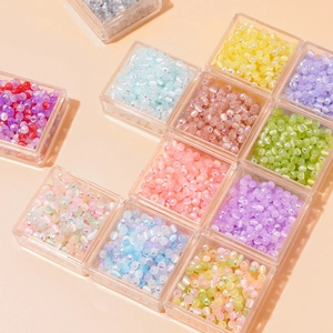 Nahaufnahme bunter irisierender Glasperlen in transparenten Kunststoffboxen für DIY-Schmuck