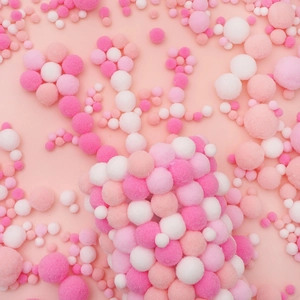 Close-up of assorted pink and white DIY plush pompoms arranged in flower shapes