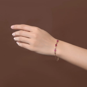 Bracelet luxueux en or rose avec des pierres de tourmaline rose ovales sur un poignet