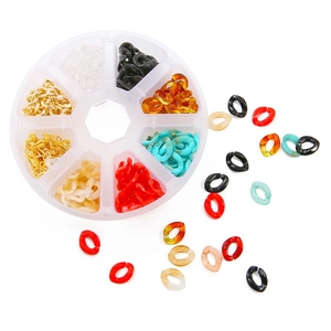 Makroansicht bunter Acryl-Gliederringe und goldener Ohrhaken in einer 8-Gitter-Box