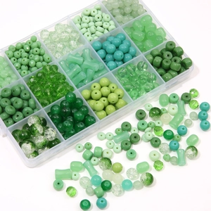 DIY jewelry kit with green glass beads and crystal charms in a 15-grid storage box