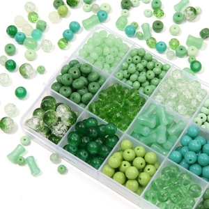 Detail of green DIY bead kit with round and faceted beads in a clear storage box