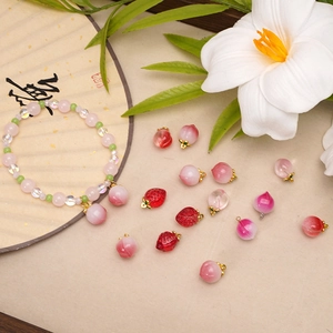 Detail of beaded bracelet with peach charms and strawberry pendants in Chinese style scenery