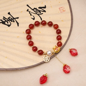 Detailed shot of handmade oriental bracelet with lucky charms and gold red beads