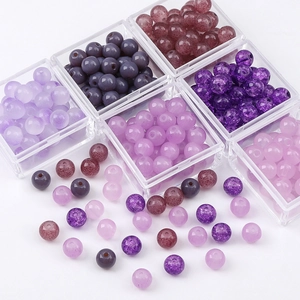 Macro view of purple assorted crystal glass beads for DIY jewelry in a clear storage box