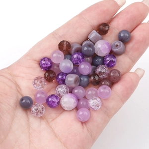 Detailed assortment of purple glass beads for DIY jewelry making held in hand