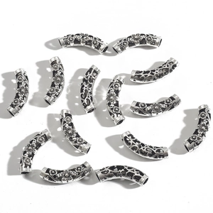 Detailed macro view of retro hollow silver alloy tube beads with floral vine patterns
