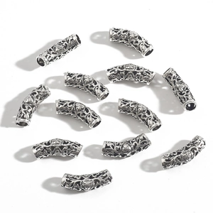 Macro detail of hollow alloy tube beads with vintage engraved skull patterns for DIY jewelry