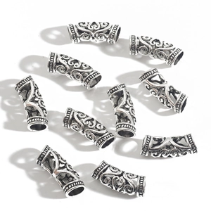 Detailed view of ten antique silver hollow alloy spacer beads with Celtic scroll patterns