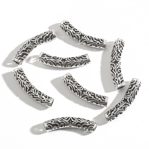 Detailed macro view of vintage silver hollow curved tube beads with star pattern
