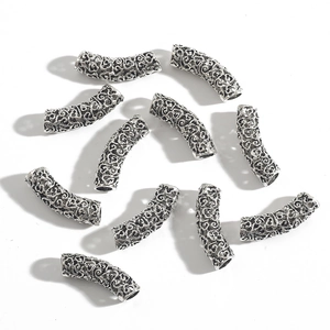 Macro detail of vintage silver hollow curved tube beads for DIY jewelry making