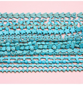 Gros plan de perles en turquoise aux formes variées comme papillon, feuille et crâne