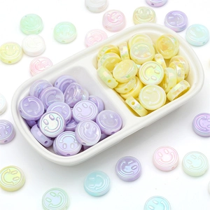 Macro view of colorful acrylic smiley face beads in pastel shades for DIY jewelry making