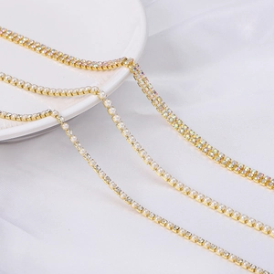 Cadenas doradas con diamantes de imitación coloridos y perlas sobre seda blanca