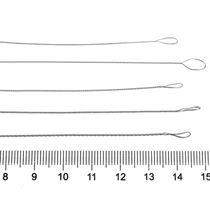 Five twisted stainless steel beaded needles for jewelry making on a ruler background