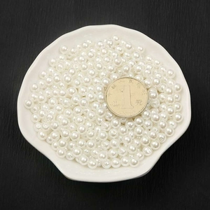 Glossy white ABS imitation pearls for DIY jewelry making displayed in a ceramic dish