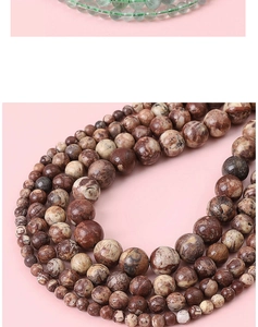 Macro detail of natural stone beads showing green and marbled brown textures for jewelry DIY